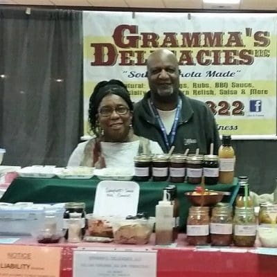 272308170_4981039201916643_5744061306781322039_n copy Angelique and Joe standing at their Gramma's Deliciaces stand with different freeze dried food options